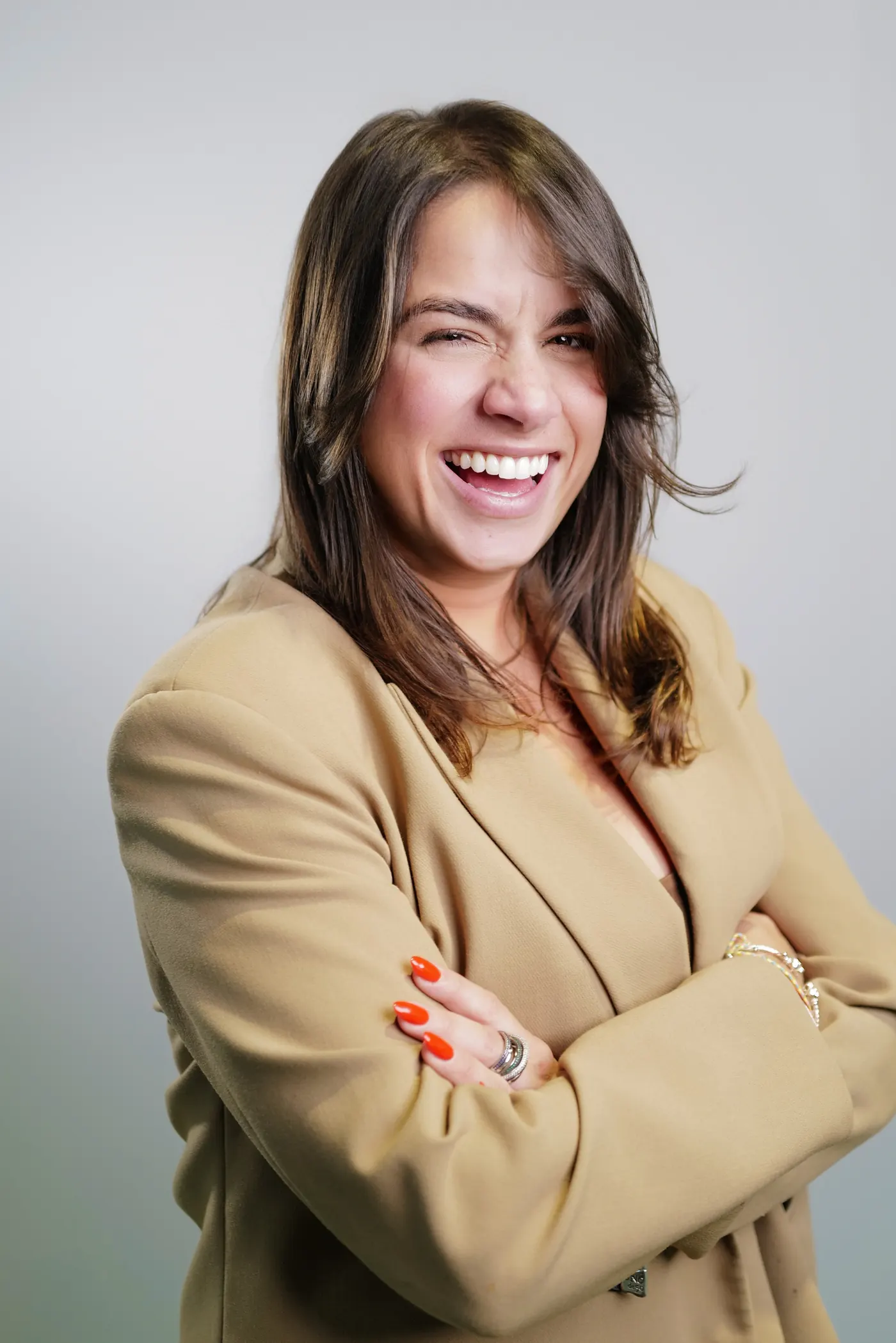 Business headshot of a smiling woman in a neutral blazer
